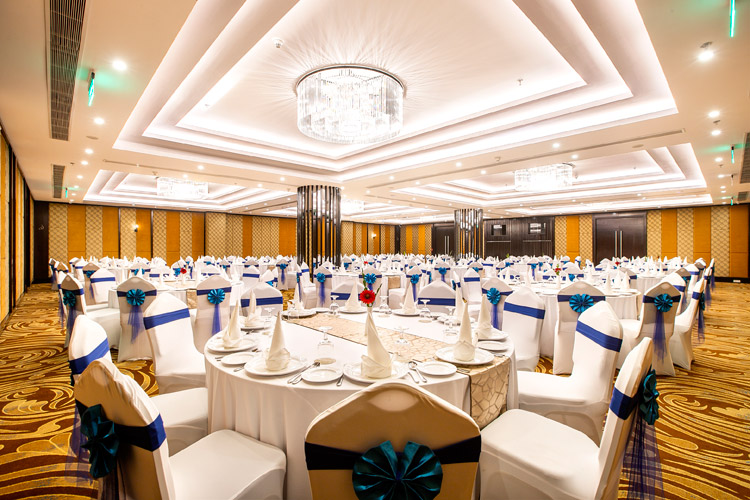 Bright double-height lobby lounge with colourful armchairs and marble columns