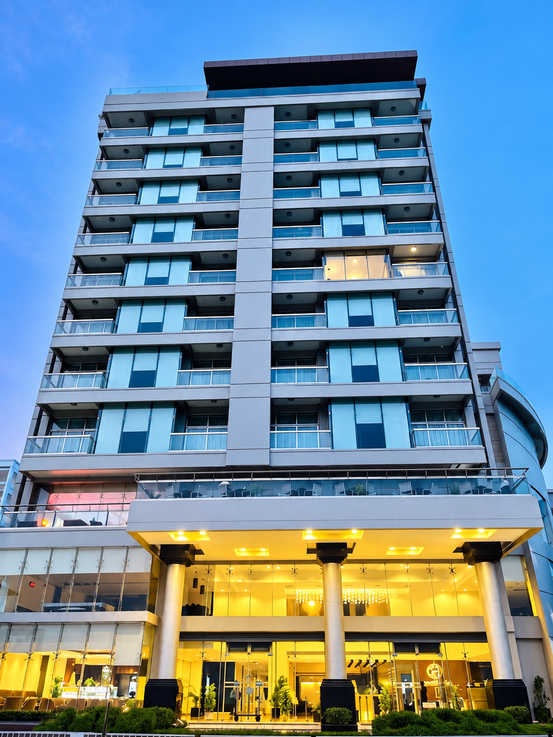 Paradise Island's hotel tower at dusk, its pillared lobby glowing warm gold